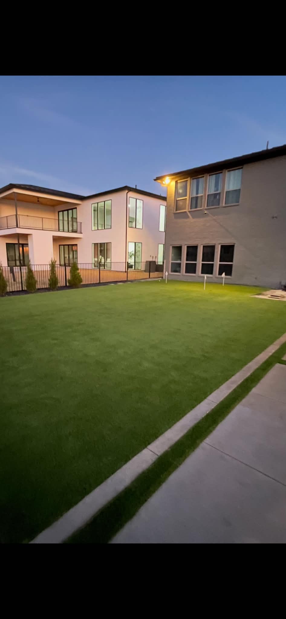 Artificial turf backyard installation at dusk